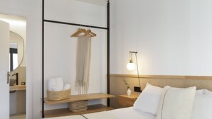 A hotel room with a bed, bedside table, hanging towel rack, and a bedside lamp. - Comfortable and functional apartment in Plaza España (Barcelona)