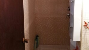 Un baño pequeño con inodoro, lavamanos y zona de ducha.