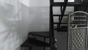A room with a bunk bed, a small table, and a chair with a woven backrest. - Villa in marina area (Chipiona)