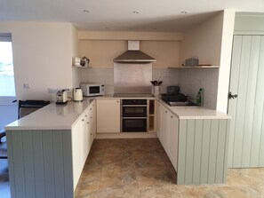 Prepare meals with ease in this kitchen featuring a central island with oven and microwave.