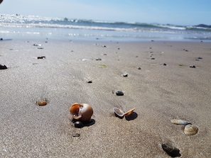 Enjoy a serene coastal experience with gentle waves and a vast expanse of sandy beach.