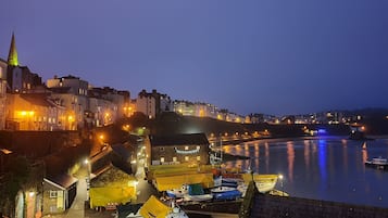 Stroll along the waterfront and discover a charming coastal town with historic buildings, a prominent church spire, and a bustling maritime scene.