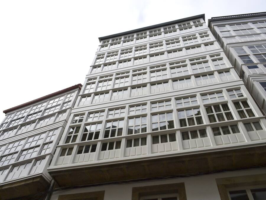 Un edificio de varios pisos con fachada enrejada y numerosas ventanas.
