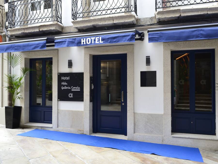 Un hotel con toldo azul y un letrero que indica que es el Hotel Aldaia Coruña.
