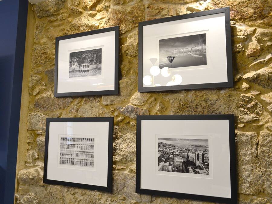 Four framed photographs on a stone wall.