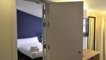 Une chambre d’hôtel avec un lit, un bureau et une télévision.
