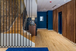 Stairs lead to an upper level, with a wooden panel wall and door to another room.