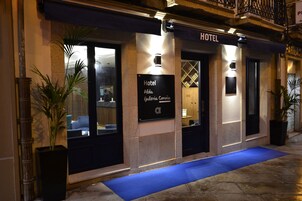 Entrada de un hotel con un cartel que indica 'Hotel Alda Galeria Coruna'.