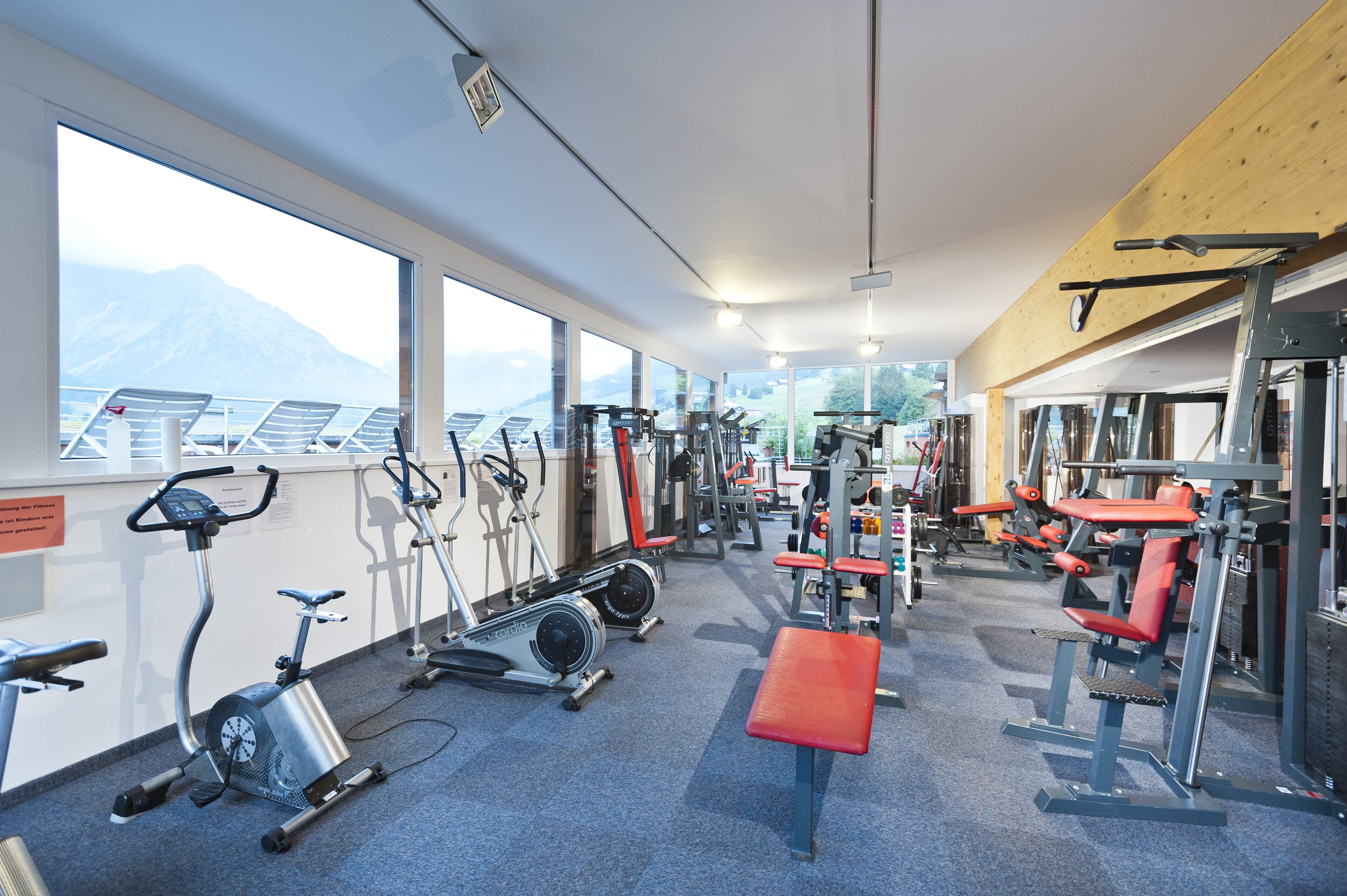 A gym with cardio machines, weightlifting equipment, and a bench.