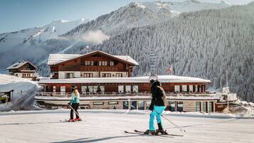A wooden lodge with a ski slope in the background.
