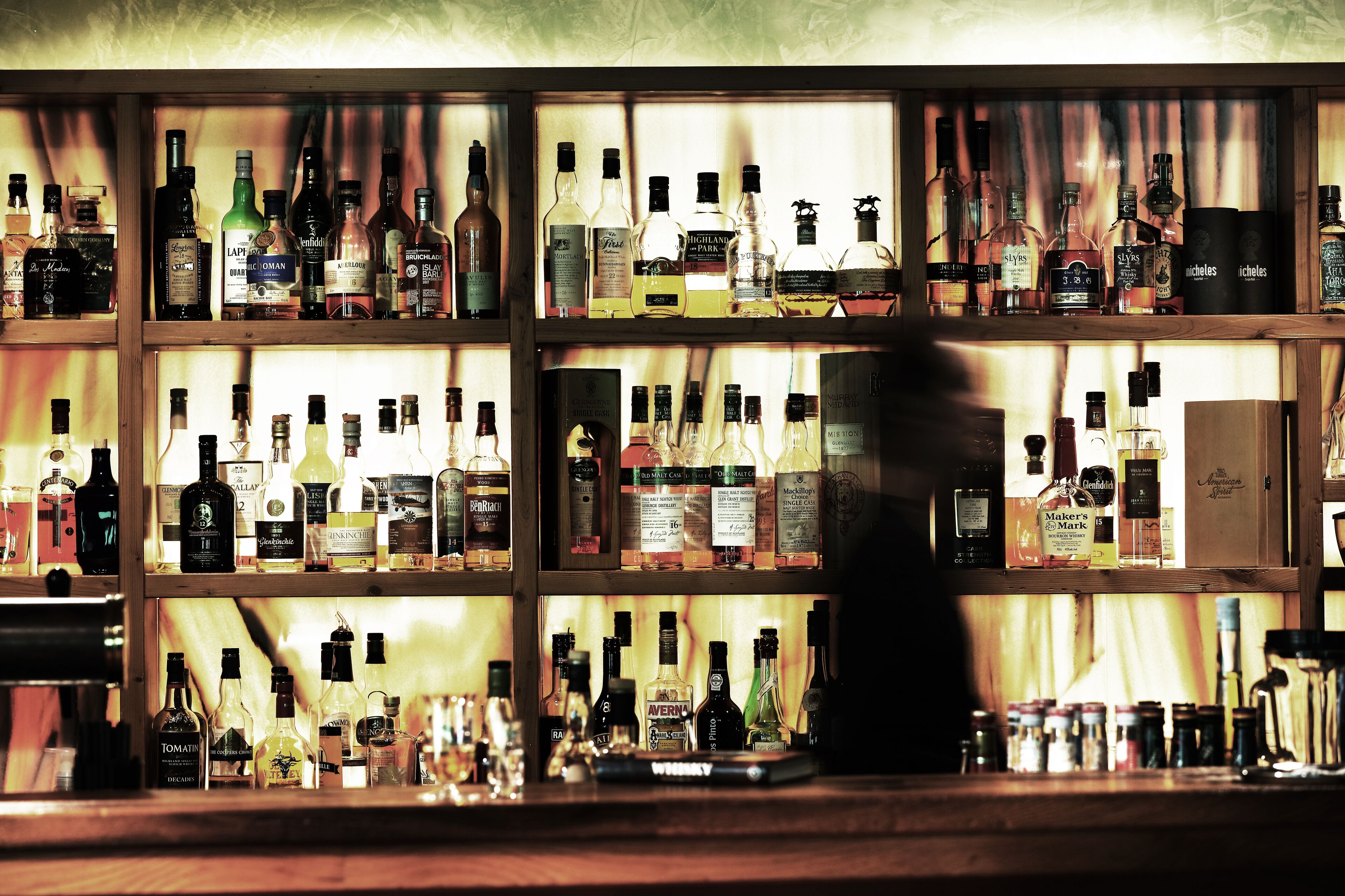 A bar with shelves of various liquor bottles.