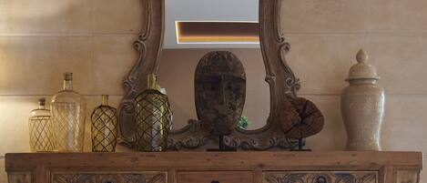 A wooden dresser with ornate carvings and a large mirror above it.