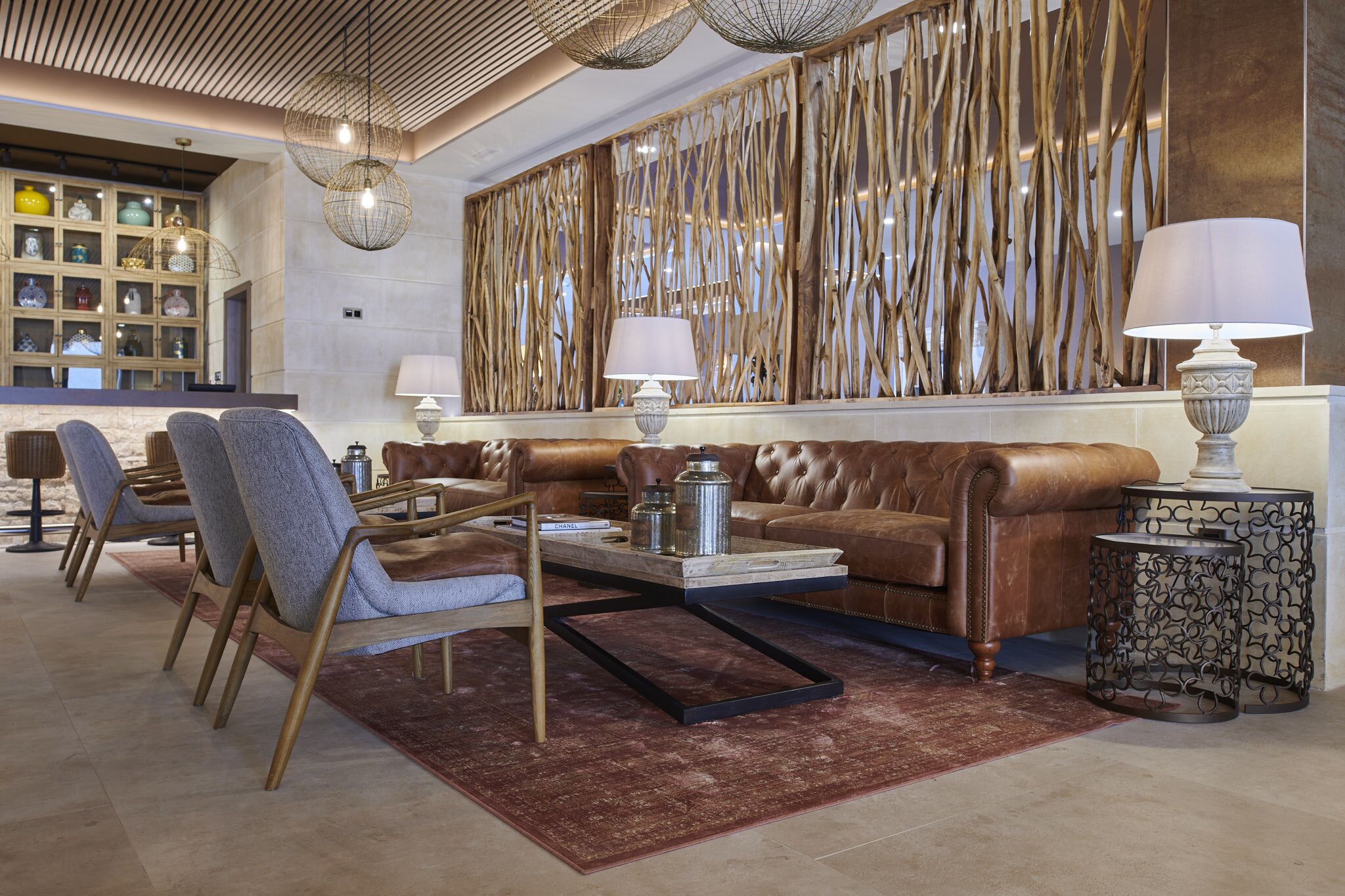 Un área de descanso moderna con sofás de cuero, una mesa de centro y un muro decorativo.