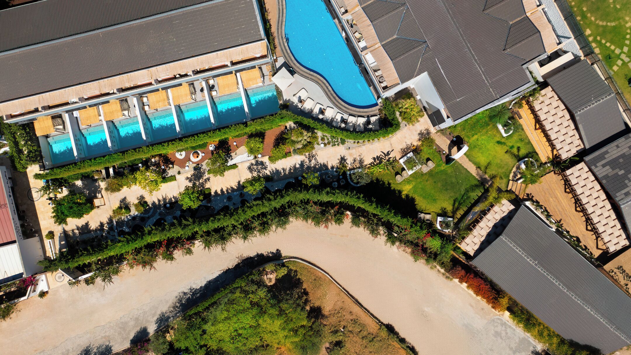 Una piscina al aire libre, sombrillas, sillones reclinables de piscina