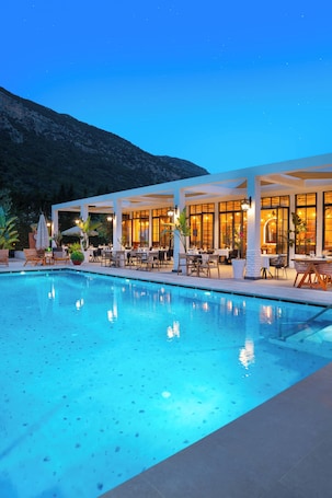 A poolside area with outdoor seating and a mountain backdrop.