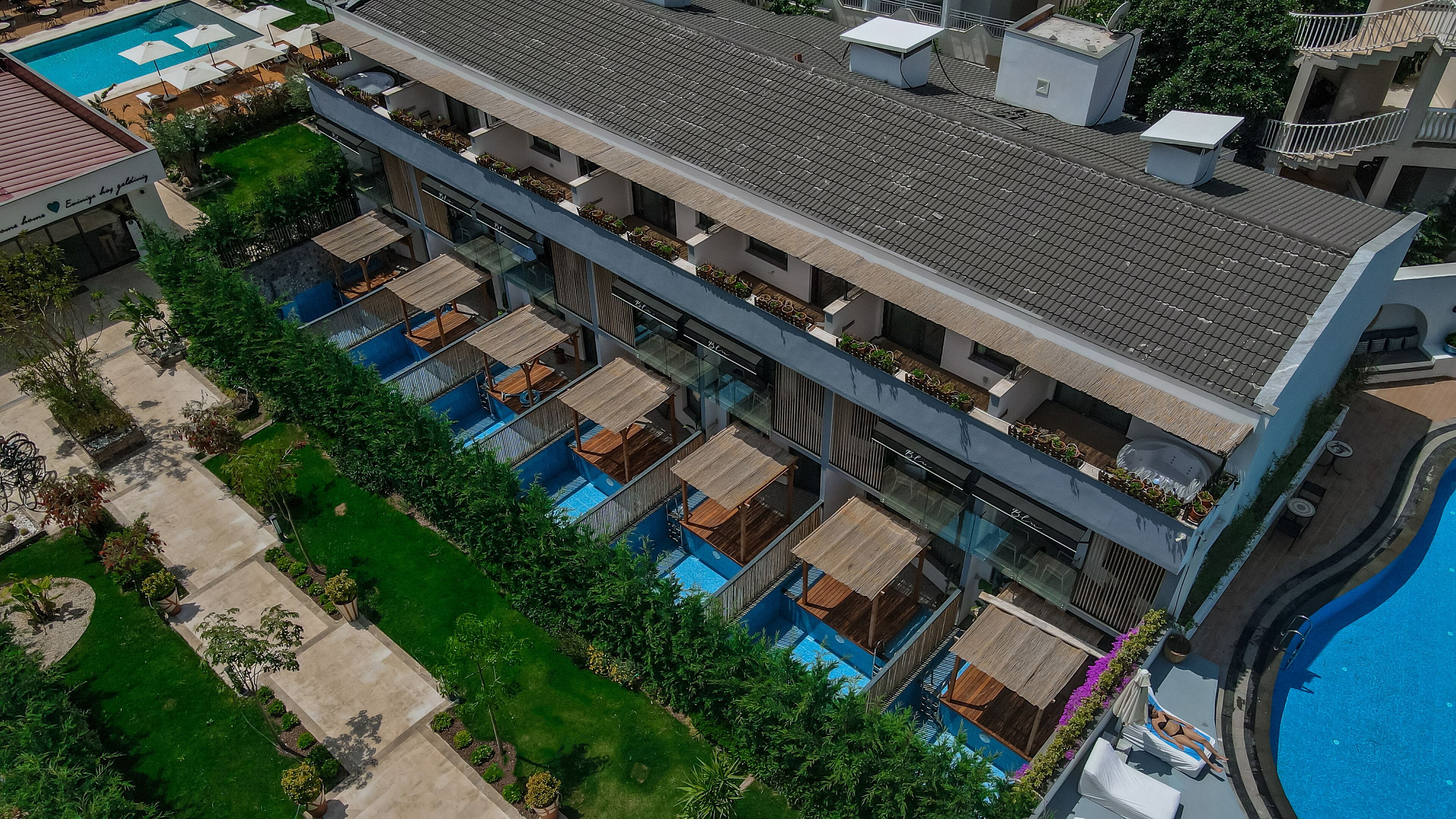 Un hôtel moderne doté de plusieurs piscines, d’espaces de détente en plein air et d’une végétation luxuriante.