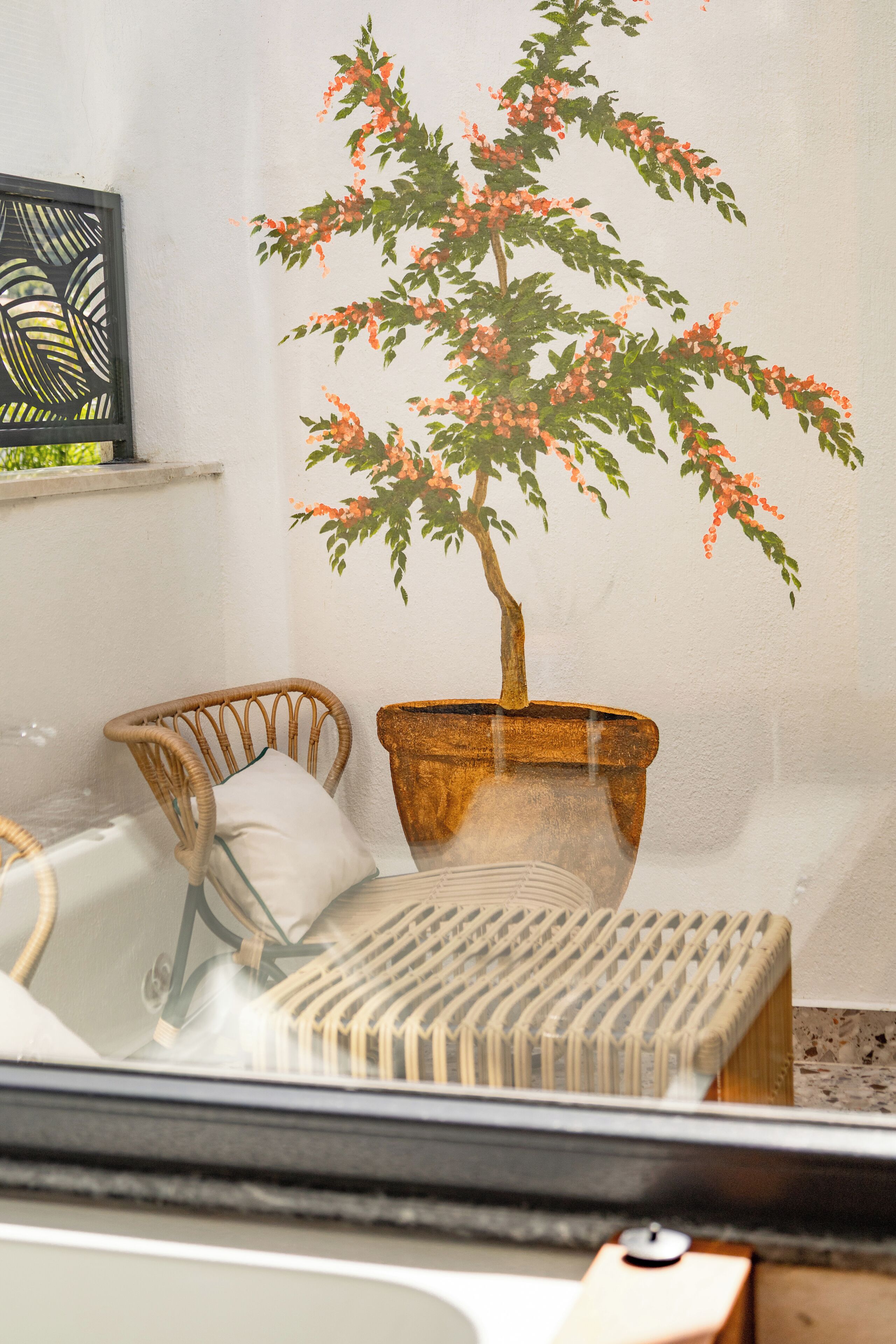 A room with a chair, a small table, and a potted plant.