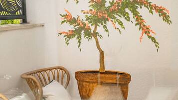 A room with a chair, a small table, and a potted plant.