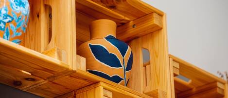 A wooden display case containing a ceramic vase with blue leaf patterns.