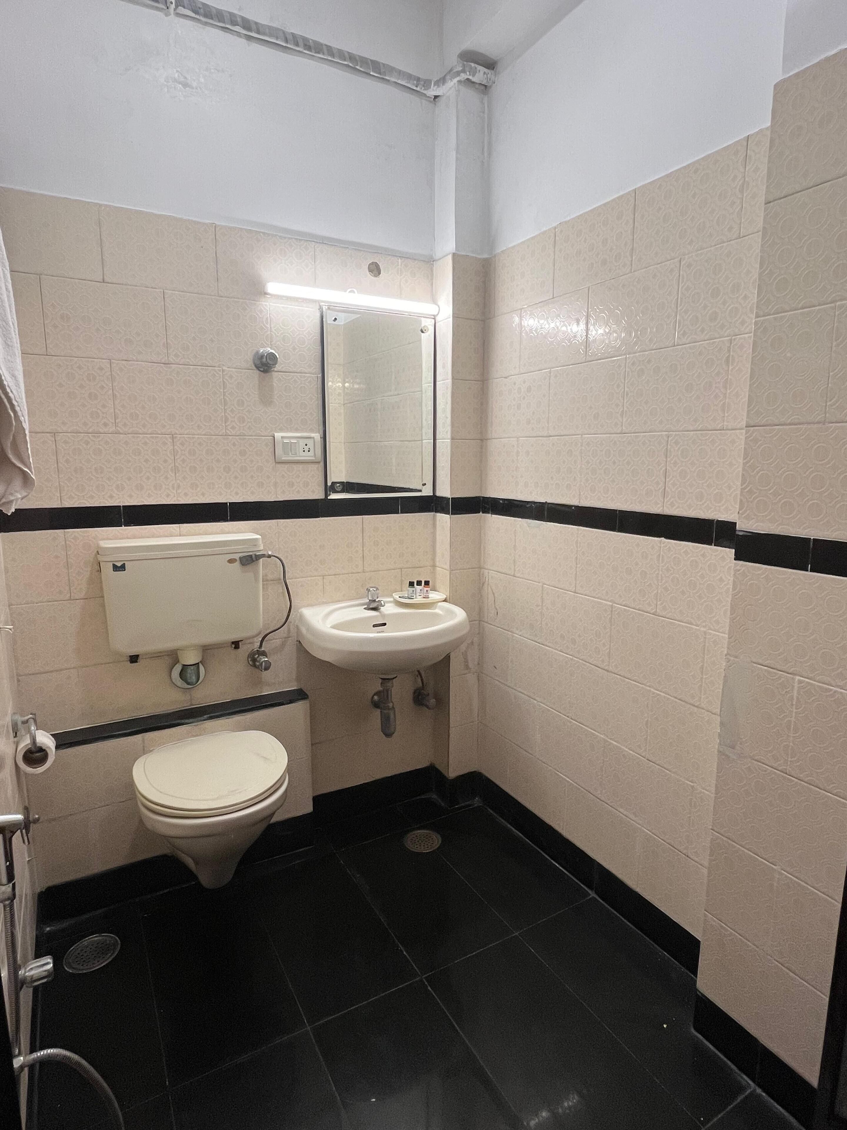 A small bathroom with a toilet, sink, and mirror.