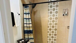 A compact bathroom with a toilet, shower, and a small sink area. - Experience the passion of hospitality, cleaning, and good location! (Tampa)