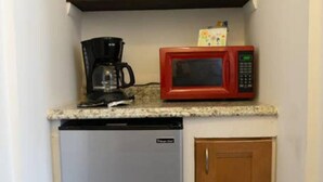 A compact kitchenette with a coffee maker, microwave, and a small refrigerator. - Experience the passion of hospitality, cleaning, and good location! (Tampa)