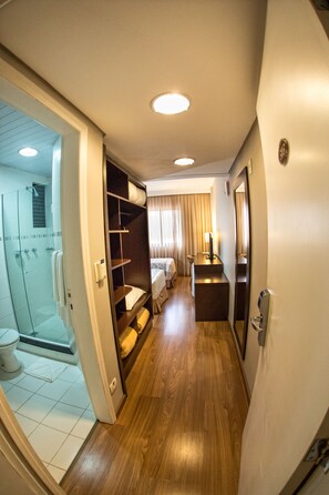 Spacious room with a large mirror, wardrobe, and a comfortable bed.