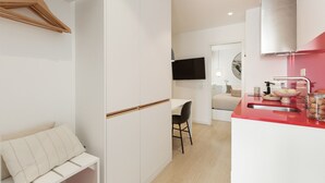 Eine moderne Küche mit roter Arbeitsplatte, einer weißen Spüle und einem Essbereich mit Tisch und Stühlen.