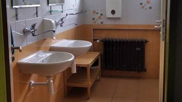 A bathroom with two sinks, a window, and a radiator.
