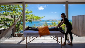 Une séance de massage sur une terrasse en bois avec vue sur la mer.