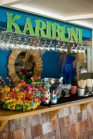 A counter with a sign reading "Karibuni," a basket of colorful fruits, and various utensils.