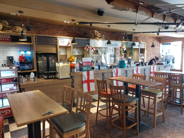 A restaurant interior with wooden tables and chairs, a bar area, and a counter with a menu.
