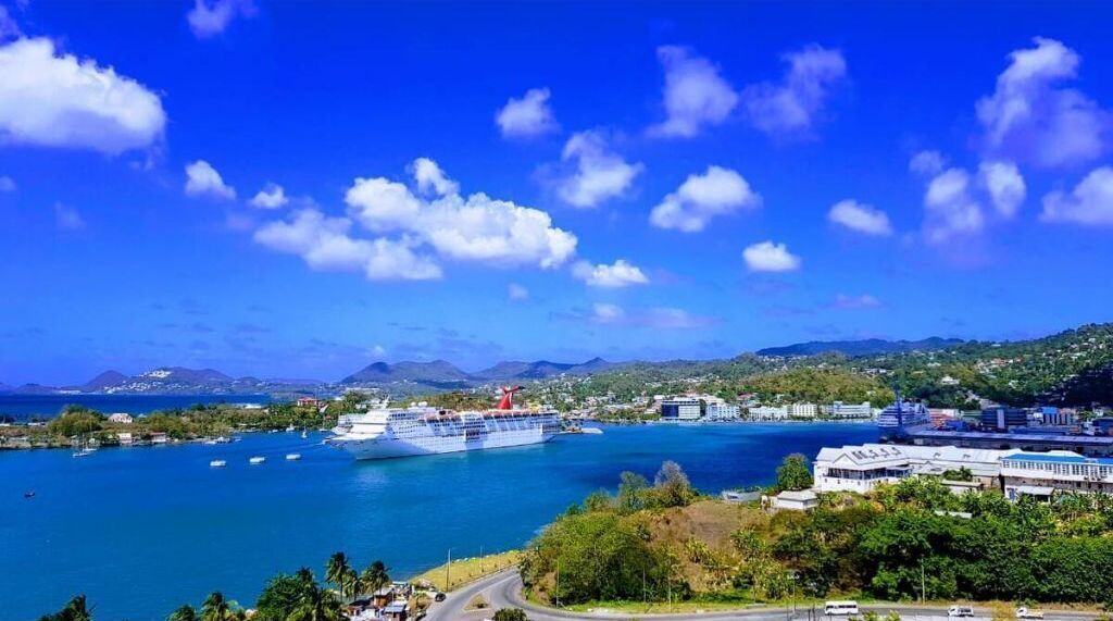 Un crucero amarrado en un puerto, con cielo azul despejado y mar en calma.