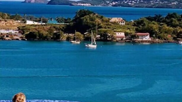 Una piscina con vistas al mar y montañas lejanas.