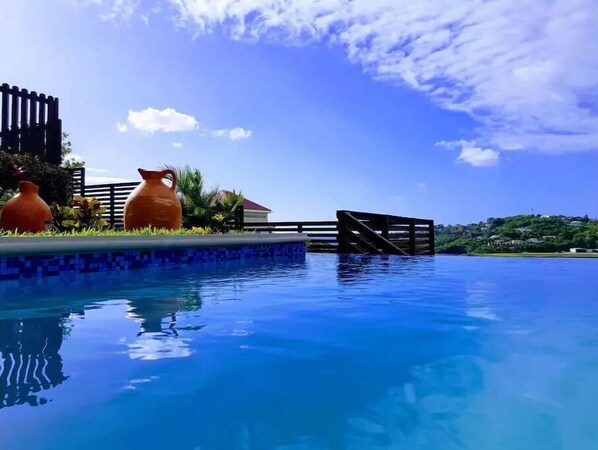 A clear blue pool with a tiled edge, surrounded by a wooden deck and two terracotta pots. - Ocean Crest (Coral Vista) - 3-Bedroom Sea View Villa! (Castries)