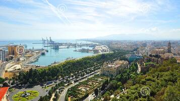 Un paisaje urbano costero con un puente destacado, un puerto deportivo y una mezcla de edificios residenciales y comerciales.