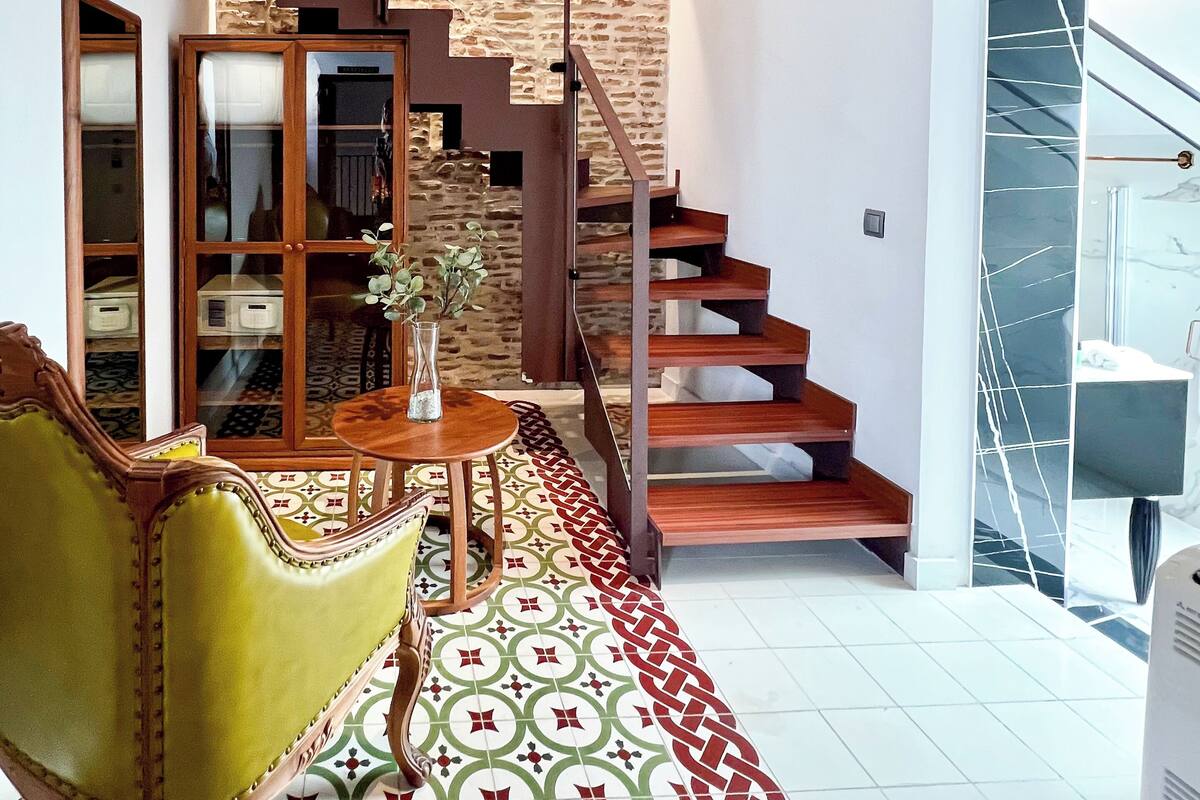 Una escalera de madera con barandilla de cristal que sube a un segundo piso.
