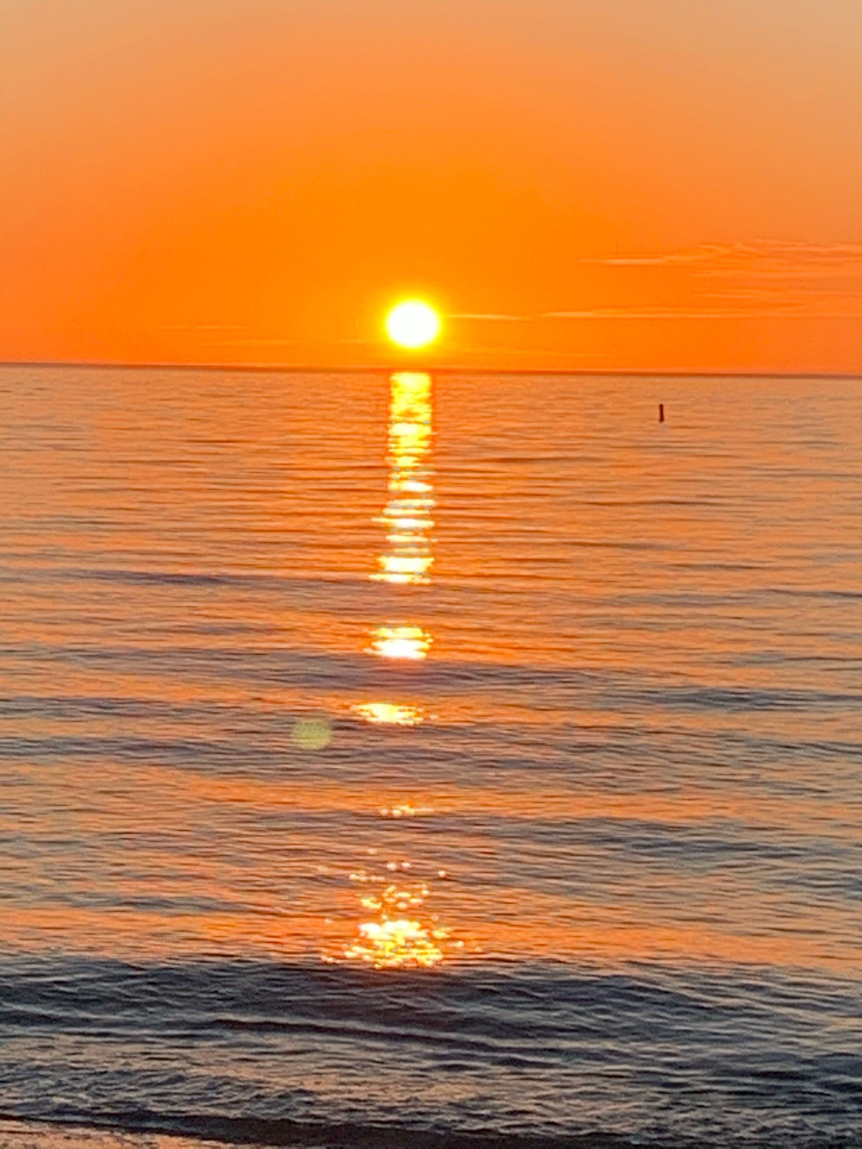 Atardecer sobre un mar tranquilo con horizonte visible.
