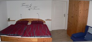 Una camera da letto con un letto in legno, una sedia blu e una porta bianca.