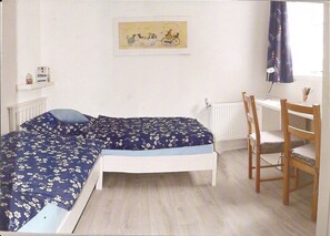 Une chambre à coucher avec un lit, un bureau et une chaise.