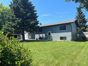 A two-story house with a well-maintained lawn and a large tree in the yard. - Beautiful home in quiet neighborhood (Sturgis)