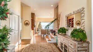 A spacious hallway with a wooden floor, a large mirror, and a Christmas tree. - Beach house no-bank waterfront 4-bedroom vacation home on Camano Island (Camano)