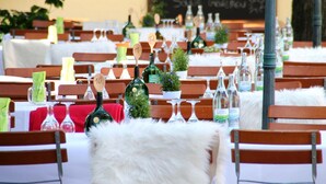 A restaurant setting with multiple tables, each with numbered place cards and wine bottles. - Bruckertshof Hotel (Bamberg)