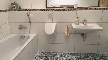 Une salle de bain avec une baignoire, des toilettes et un lavabo.