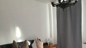 Et soveværelse med en stor seng, et natbord, en lampe og en loftlampe.