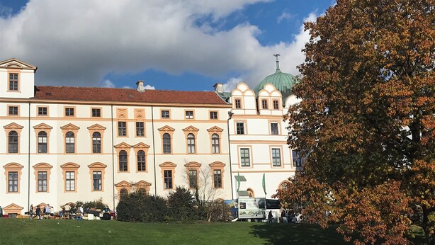 En stor, historisk bygning med mange vinduer og en grøn kuppel.