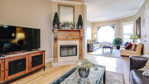 A living room with a fireplace, a television, and a sofa. - Old-World, Classic Building Downtown (Chicago)
