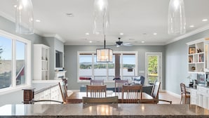 A spacious kitchen with granite countertops, wooden chairs, and pendant lighting. - COZY, LUXURY LAKE HOUSE W/ STUNNING LAKE VIEWS!! (Lake Hamilton)