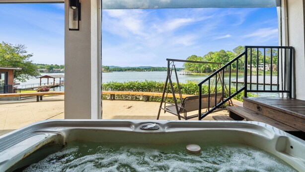 A hot tub with a view of a lake, wooden deck, and a metal staircase. - COZY, LUXURY LAKE HOUSE W/ STUNNING LAKE VIEWS!! (Lake Hamilton)