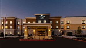 Una entrada de hotel moderna con un letrero que dice "Homewood Suites".